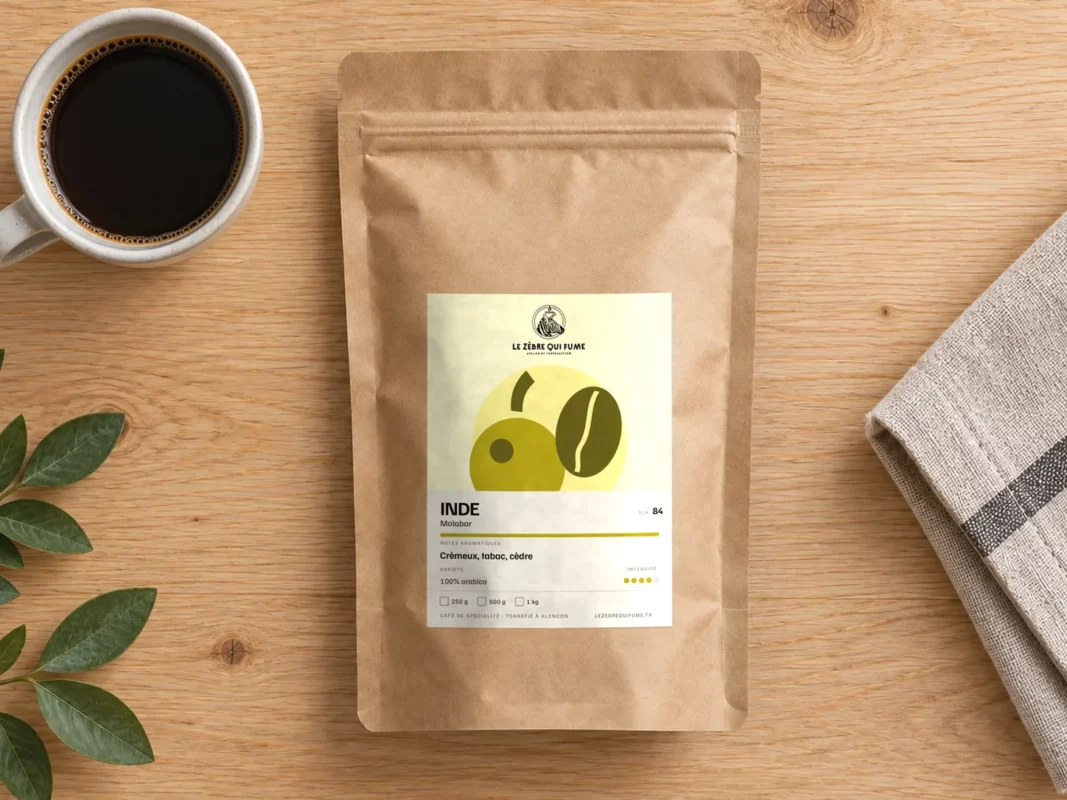 Sachet de café Inde Malabar et une tasse de café vus du dessus sur une table
